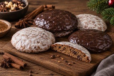 Die Grafik zeigt mehrere Lebkuchen auf einem Holzbrett. einer davon ist angeschnitten. Im Hintergrund sind weihnachtliche Gewürze wie Zimt und Nelken zu sehen.