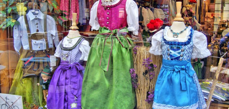 Das Bild zeigt ein Schaufenster mit verschiedenen Dirndln.