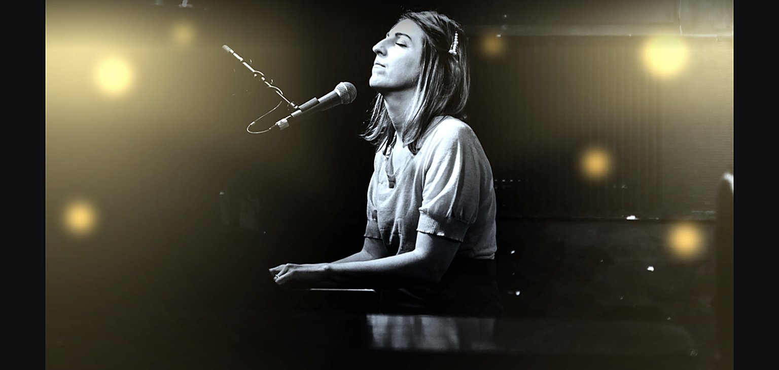 Auf dem Bild ist die Sängerin und Songwriterin Anne Eck beim Klavierspielen zu sehen.