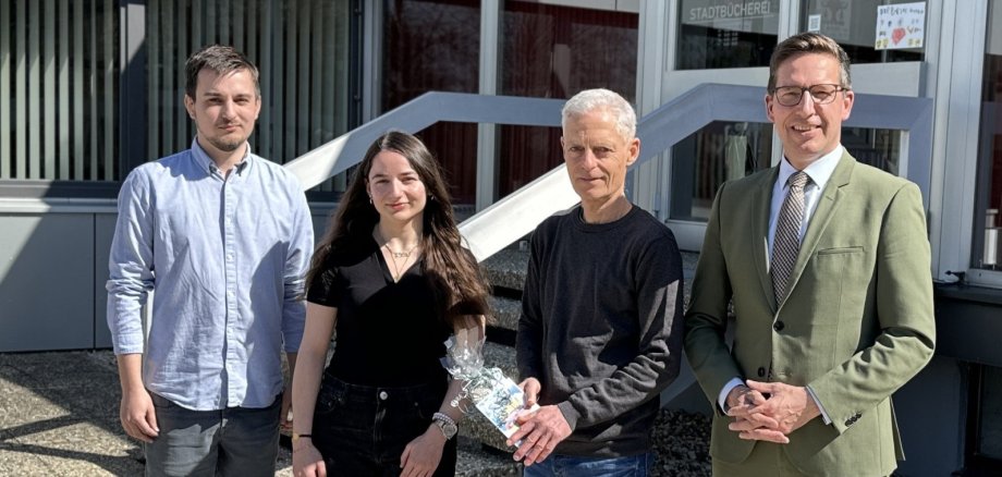 Das Bild zeigt Oliver Groll, der von Bürgermeister Michael Abraham in den Ruhestand verabschiedet wird. Außerdem sind Michel Seifert und Melek Atmaca, das neue Team der Bücherei, zu sehen.