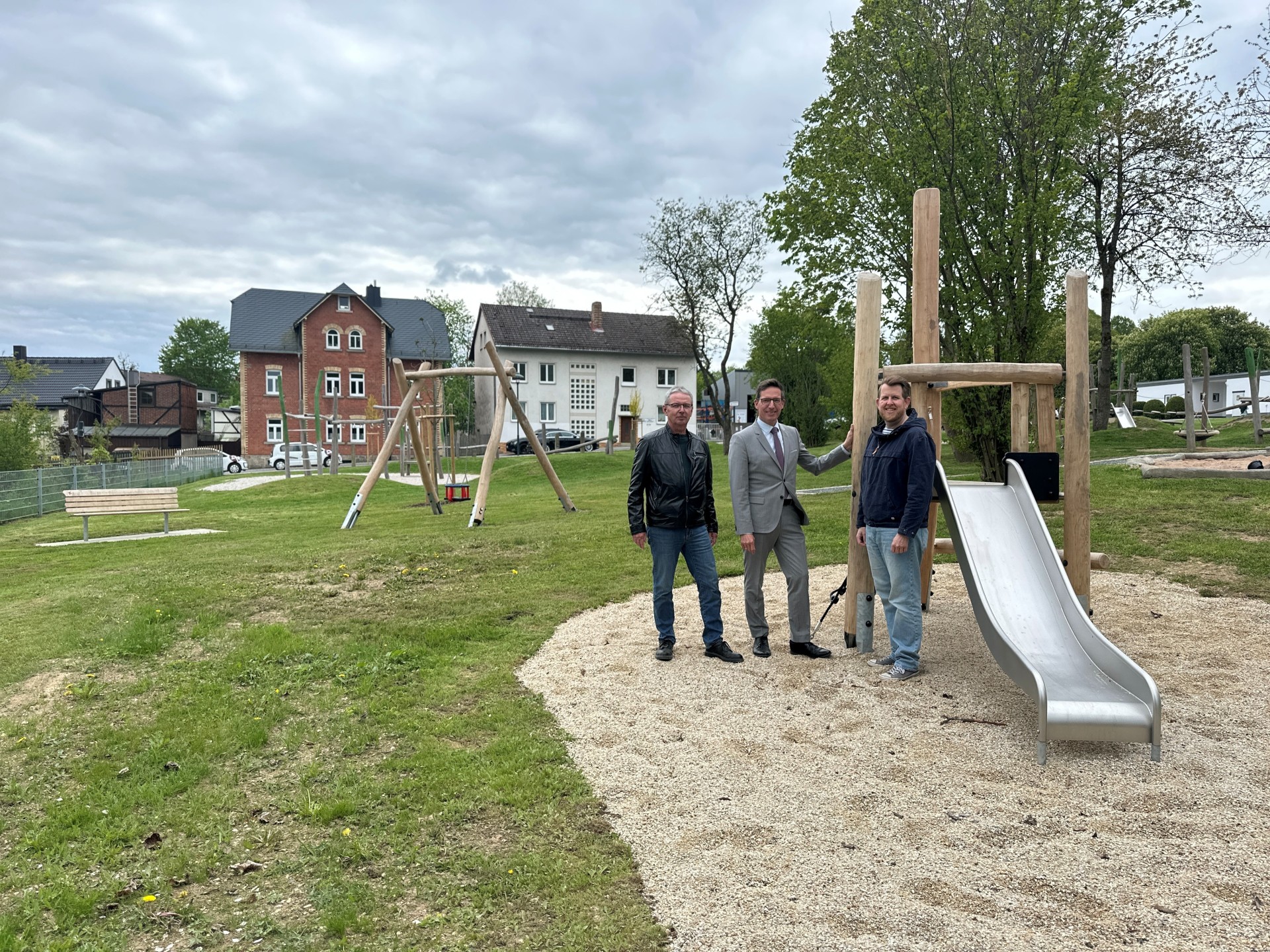 Auf dem Bild ist von links nach rechts vor den neuen Spielgeräten am Spielplatz Kronengarten zu sehen: Jürgen Schrödel (Mitarbeiter des Bauamts der Stadt Rehau), 1. Bürgermeister der Stadt Rehau Michael Abraham und Zahnarzt Christian Bonnekamp.