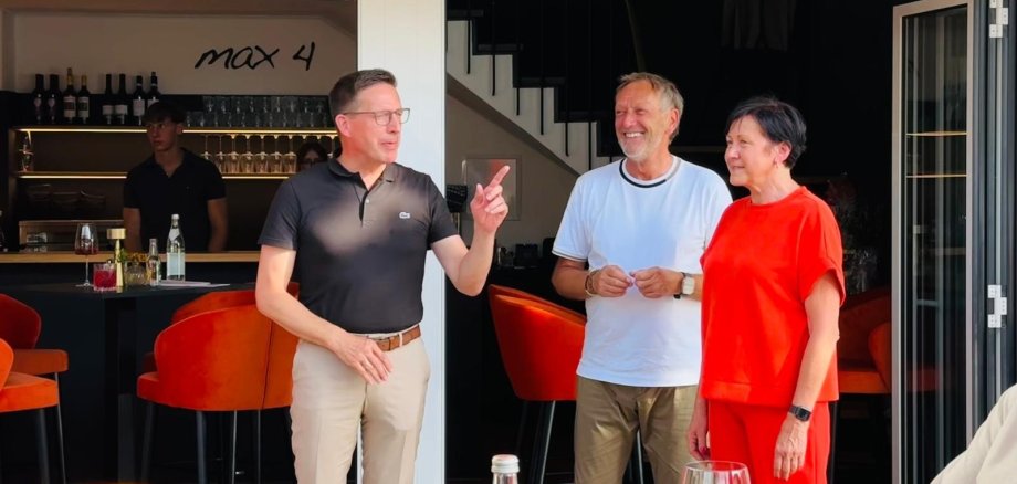 Auf dem Bild ist Bürgermeister Michael Abraham neben den Inhabern der neuen Vinothek "Max4" Thea Menger und Walter Ehmann zu sehen.