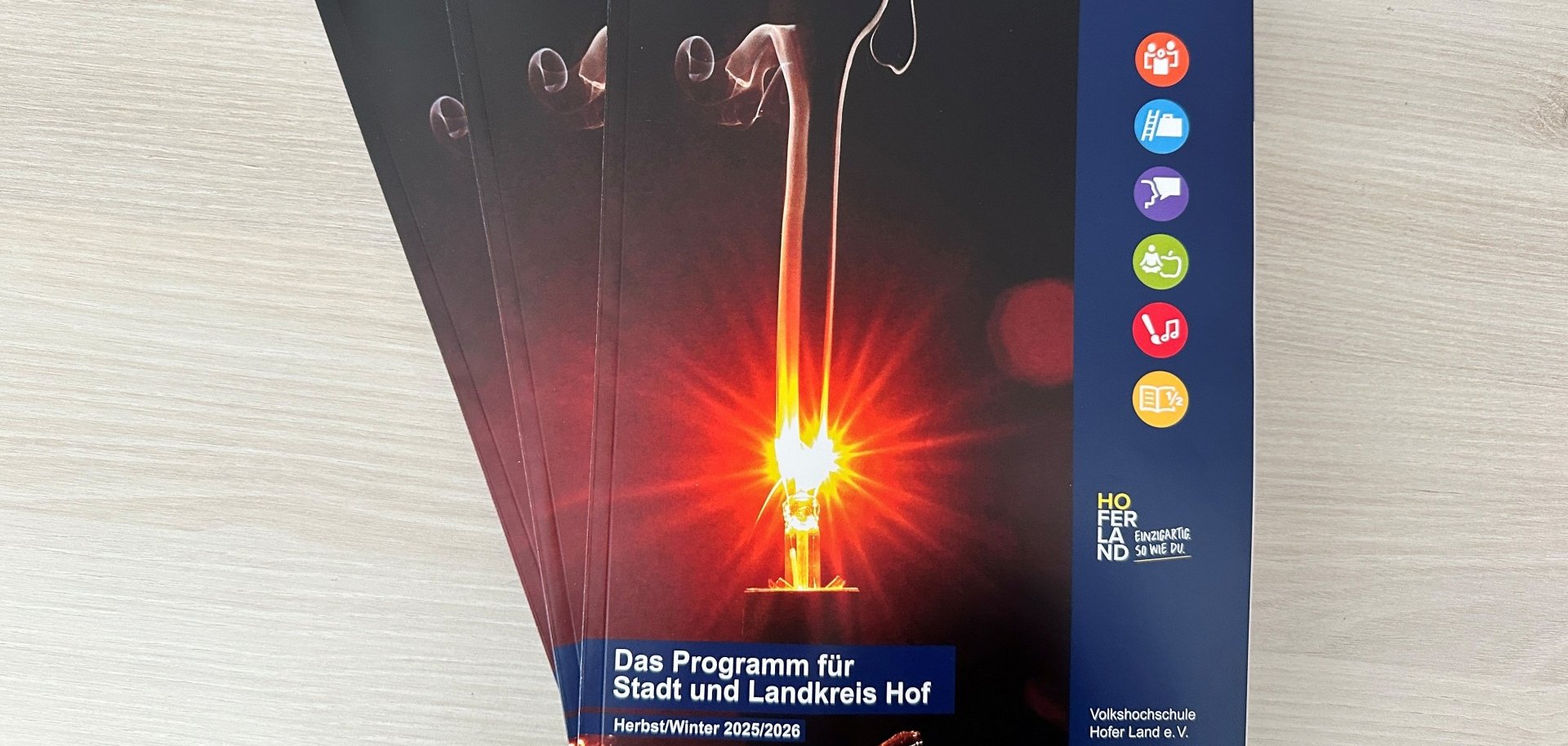 Das Bild zeigt mehrere VHS Herbst/Winter-Programme übereinander liegend.