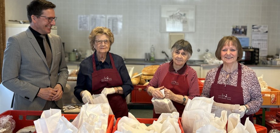 Das Bild zeigt Bürgermeister Michael Abraham neben Waltraud Rödel, Erika Kopp und Waltraud Marx, welche die Essensausgabe für die Hofer Tafel in Rehau vorbereiten.