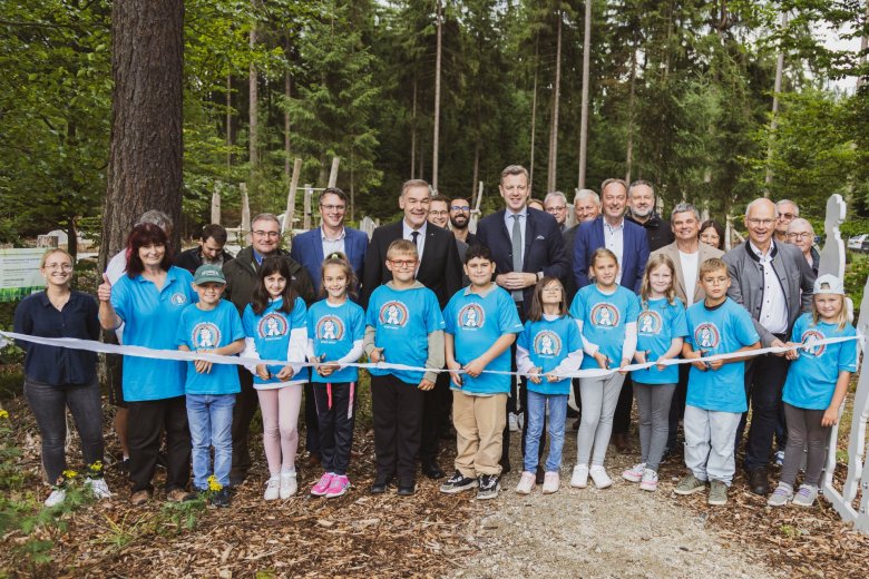 Das Bild zeigt die Verantwortlichen sowie einige Kinder beim Durchschneiden des obligatorischen Einweihungsbands des neuen pädagogischen Bewegungsparks am Kornberg.