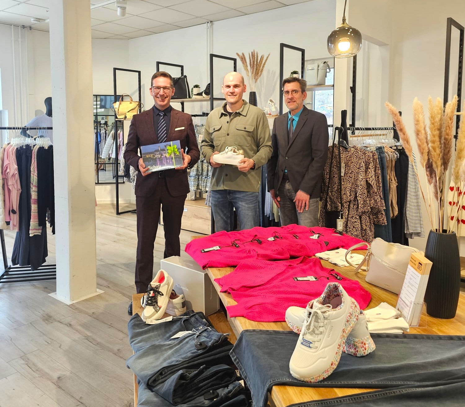 1. Bürgermeister Michael Abraham und Wirtschaftsförderer Bernd Köppel beglückwünschen den Geschäftsführer von Geyer Schuhe, Volker Dehling, zum 20-jährigen Jubiläum und überreichen ein Geschenk.