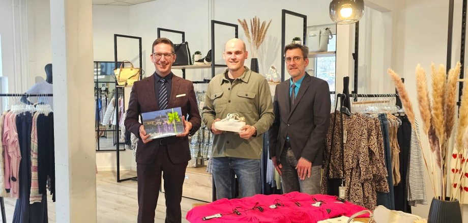 1. Bürgermeister Michael Abraham und Wirtschaftsförderer Bernd Köppel beglückwünschen den Geschäftsführer von Geyer Schuhe, Volker Dehling, zum 20-jährigen Jubiläum und überreichen ein Geschenk.