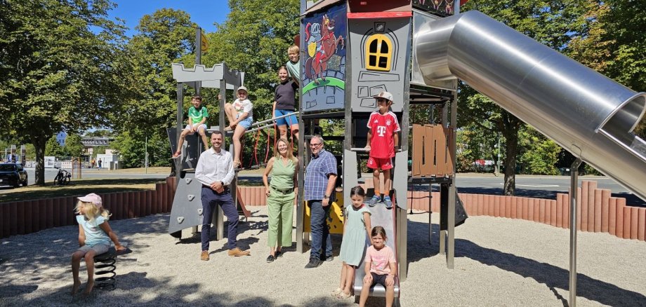 Das Bild zeigt Bauamtsleiter Dominik Gierth, 3. Bürgermeisterin Kerstin Kropf, stellvertretenden Bauhofleiter Christian Stelzig sowie einige Kinder, welche die neuen Spielgeräte gleich ausgiebig testeten.