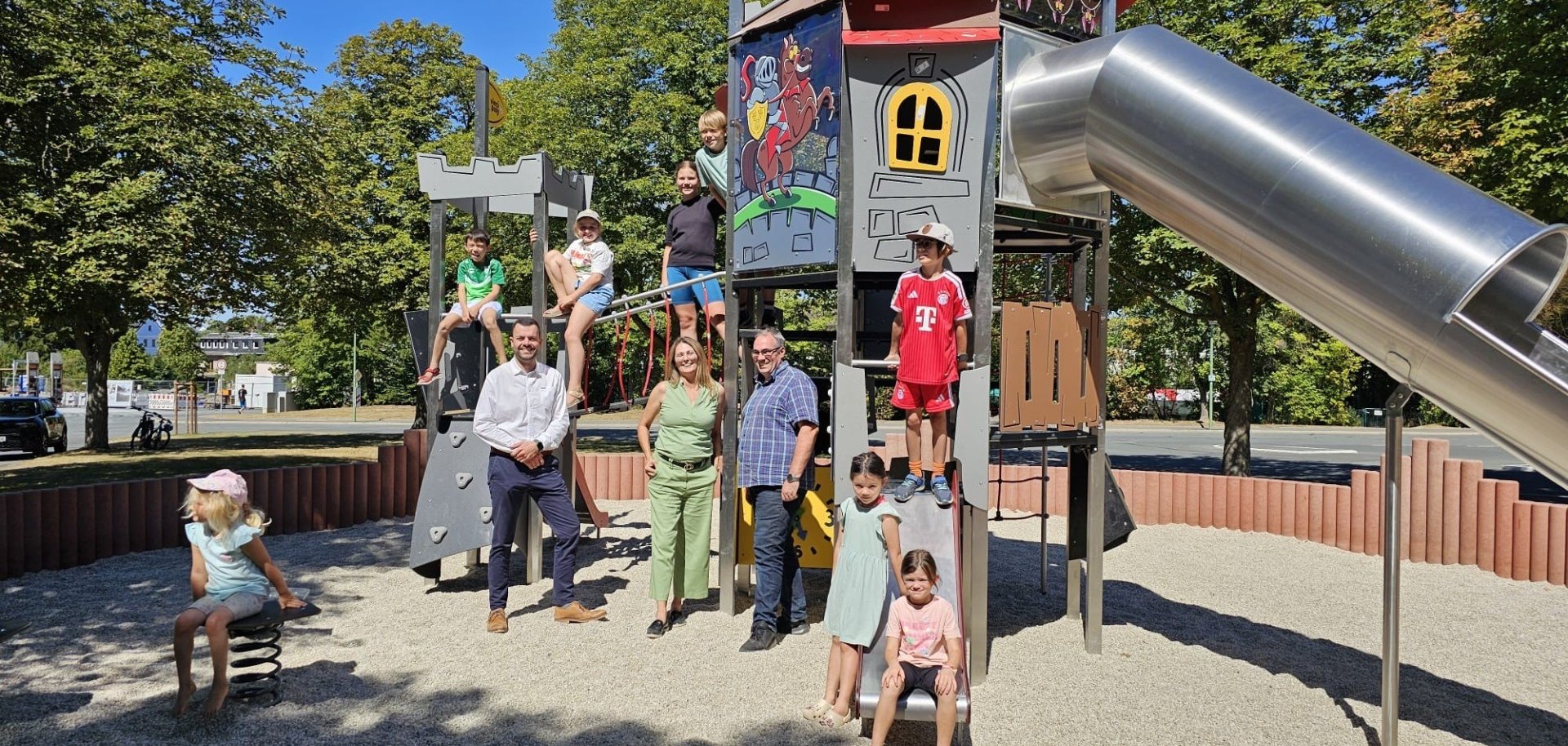 Das Bild zeigt Bauamtsleiter Dominik Gierth, 3. Bürgermeisterin Kerstin Kropf, stellvertretenden Bauhofleiter Christian Stelzig sowie einige Kinder, welche die neuen Spielgeräte gleich ausgiebig testeten.