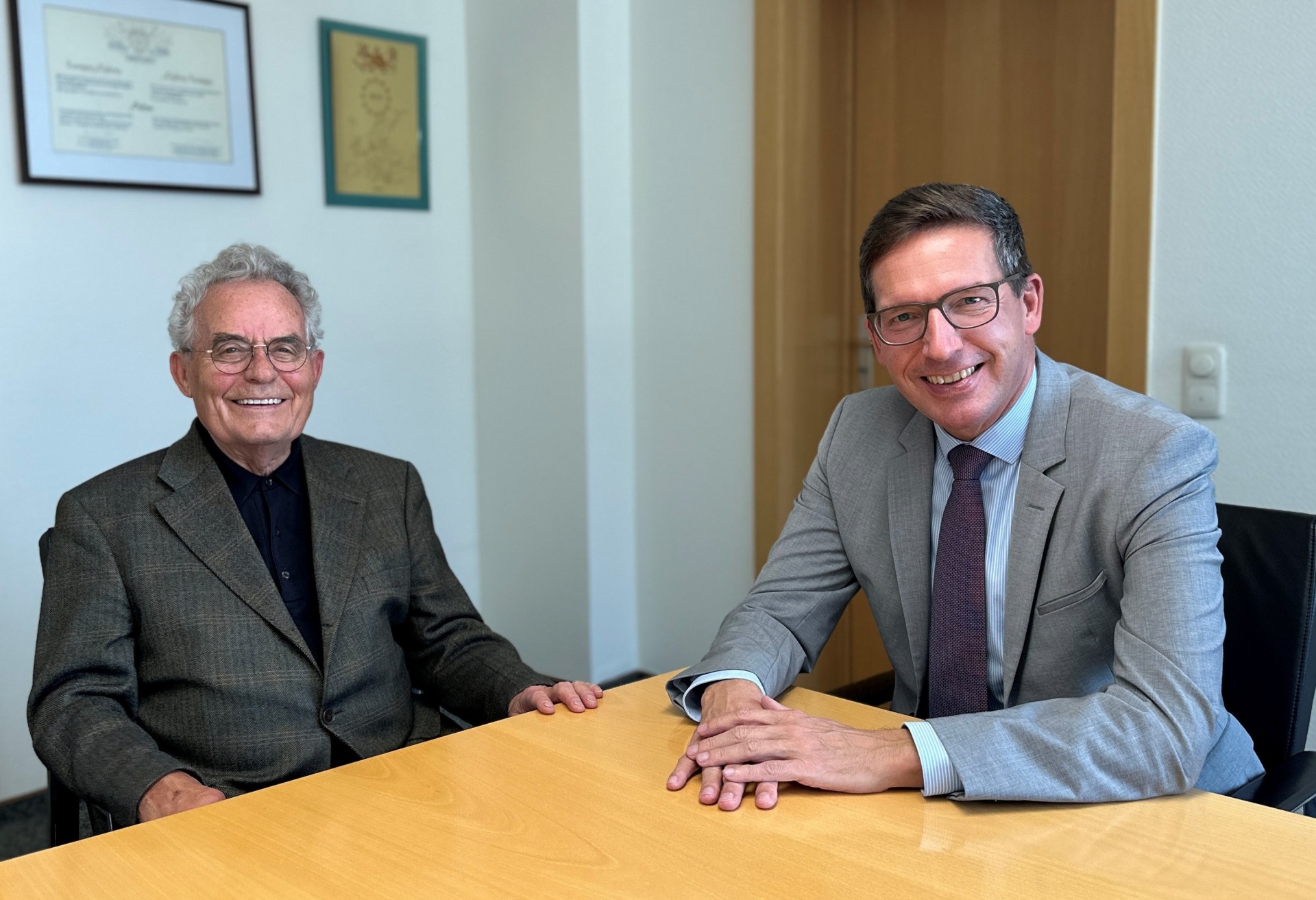 Das Bild zeigt Bürgermeister Michael Abraham und Helmut Kaufmann am Tisch im Besprechungszimmer des Bürgermeisters.