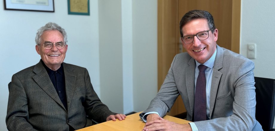 Das Bild zeigt Bürgermeister Michael Abraham und Helmut Kaufmann am Tisch im Besprechungszimmer des Bürgermeisters.
