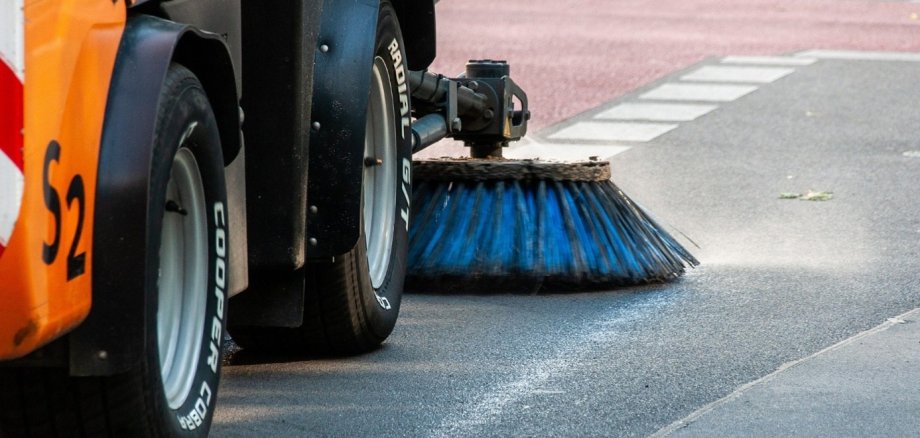 Das Bild zeigt eine Kehrmaschine auf der Straße