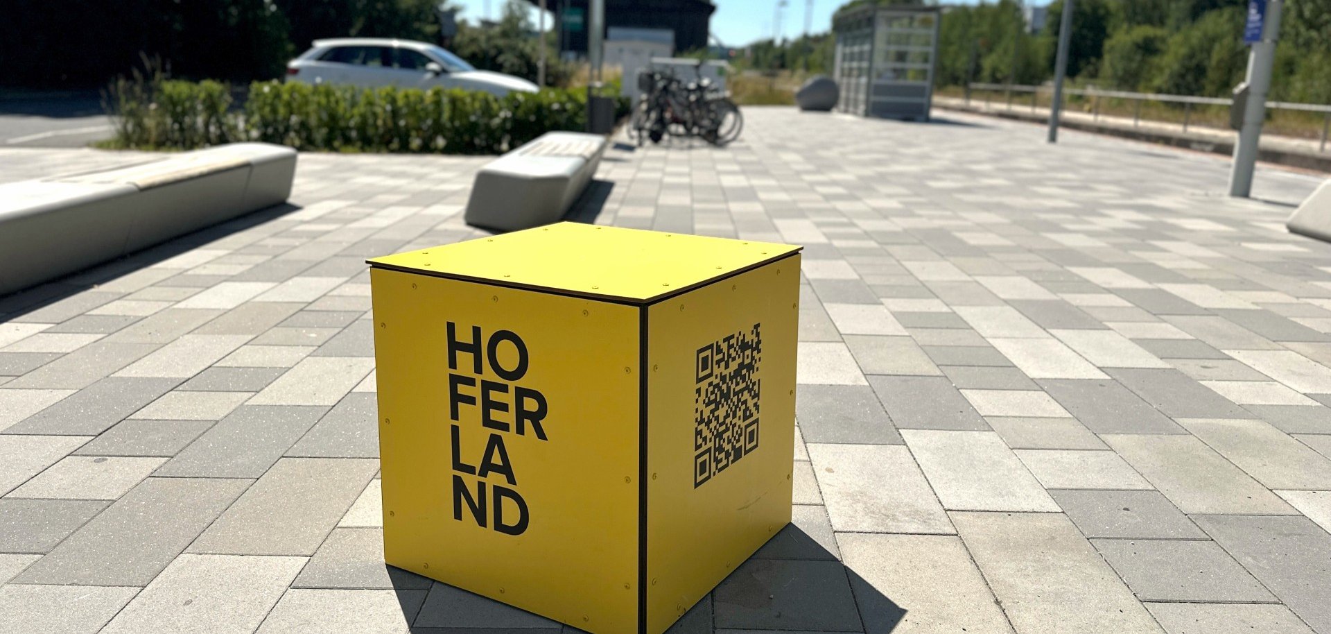 Das Bild zeigt den gelben Hofer Land-Erlebniswürfel am Rehauer Bahnhof.