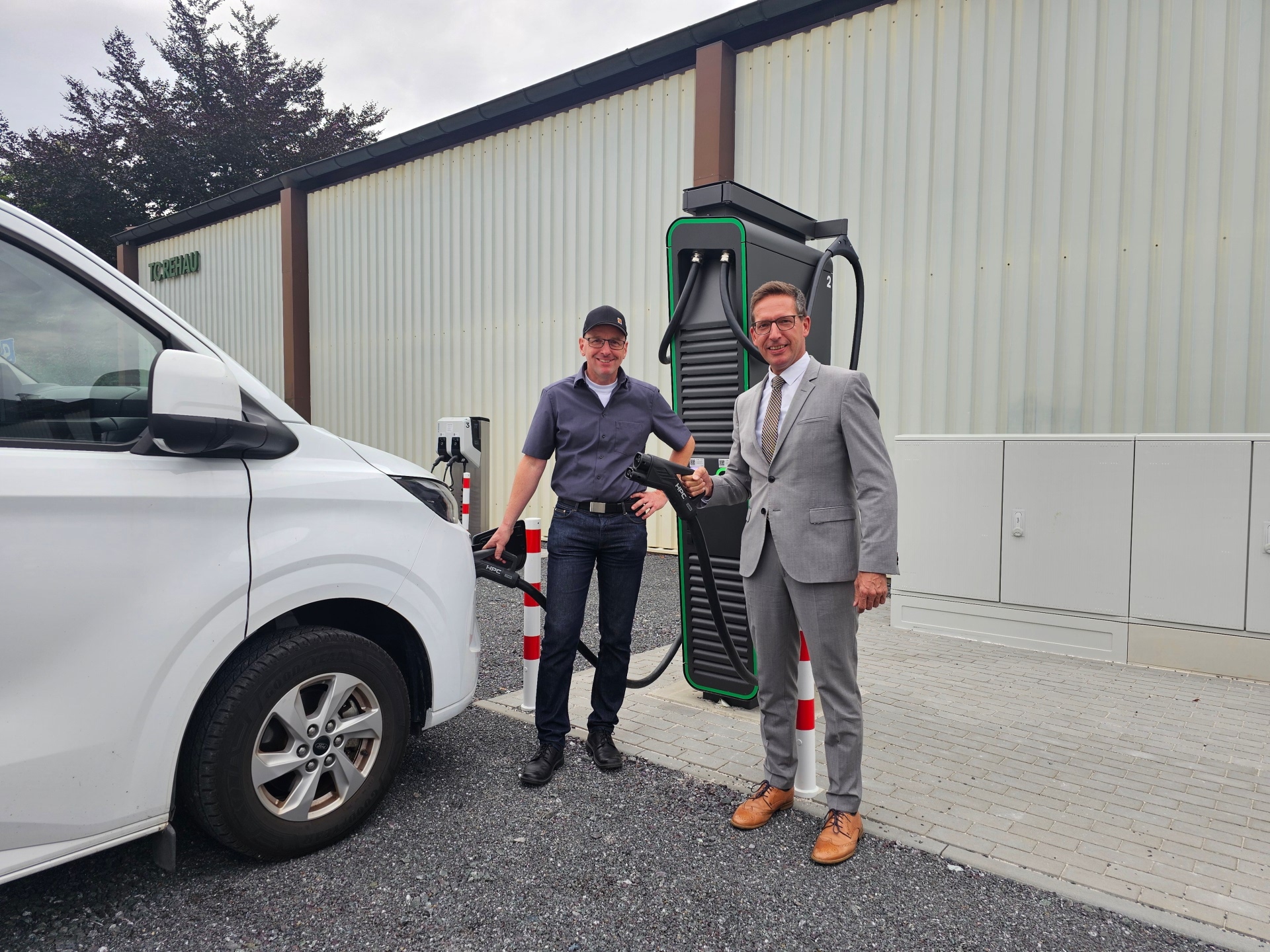 Auf dem Bild sind Bürgermeister Michael Abraham und Christian Dötsch bei der Einweihung der neuen E-Ladesäulen am Schützenfestplatz zu sehen.