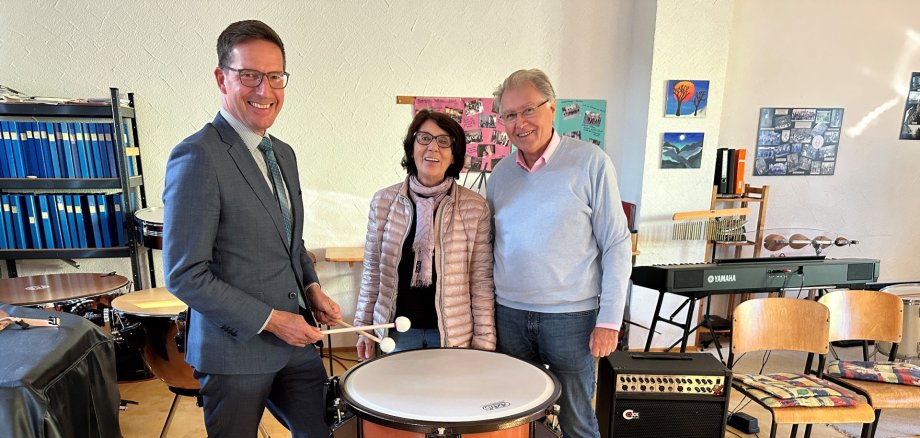 Bild zeigt Bürgermeister Michael Abraham neben Helma und Norbert Hofmann neben der neuen Kesselpauke.