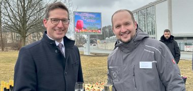 Das Bild zeigt Bürgermeister Abraham neben Geschäftsführer von inszenium, Stefan Lehmann, vor der neuen LED-Wand in Rehau.