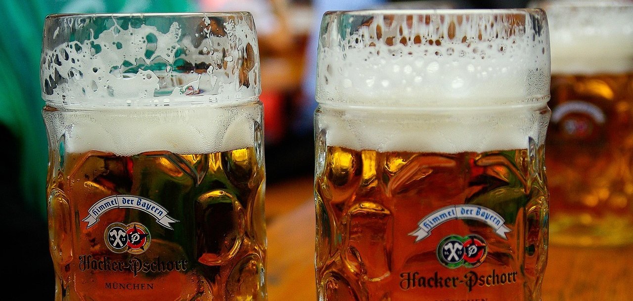 Das Bild zeigt zwei gefüllte Maßkrüge mit Bier.