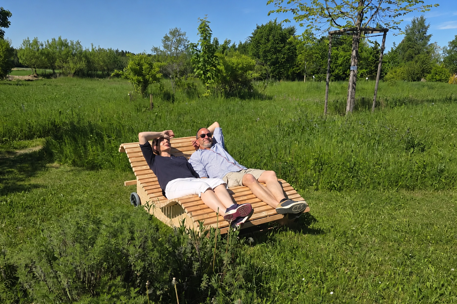 Das Bild zeigt zwei Personen, die auf einem der neuen Waldsofas liegen.