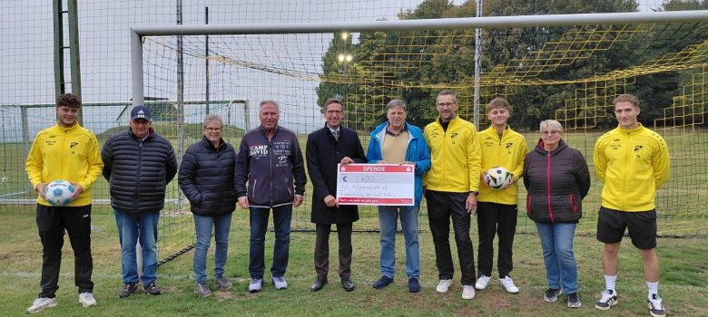 Auf dem Bild bei der symbolischen Scheckübergabe vor dem Ballfangzaun von links zu sehen: Maxi Ziesmann, Peter Rameckers, Sabine Kühnel, Roberto Sachse (2. Vorstand SGV Pilgramsreuth), Bürgermeister Michael Abraham, Spielleiter Horst Lüdtke, Trainer Guido Baumgärtner, Paul Baumgärtner, Christa Rameckers und Paul Michel.