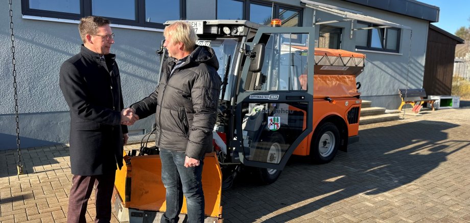 Das Bild zeigt 1. Bürgermeister der Stadt Rehau, Michael Abraham, neben Bauhofleiter Mathias Winterling bei der offiziellen Übergabe des neuen Knickschleppers für den Stadtbauhof.