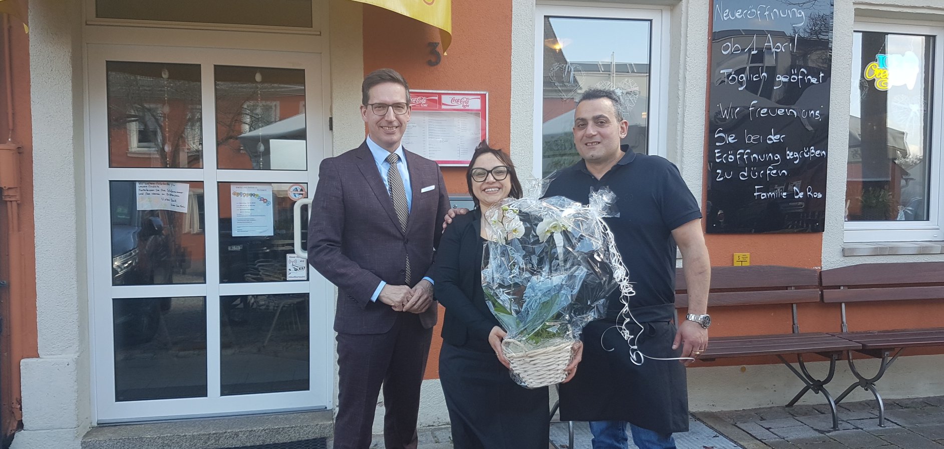 Das Bild zeigt die neuen Inhaber der Eisdiele "San Marco" am Schillerplatz, Tatiana De Ros und ihren Ehemann Marco, neben Bürgermeister Michael Abraham.