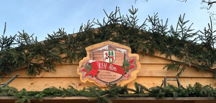 Das Bild zeigt das Außenschild der REH-Alm