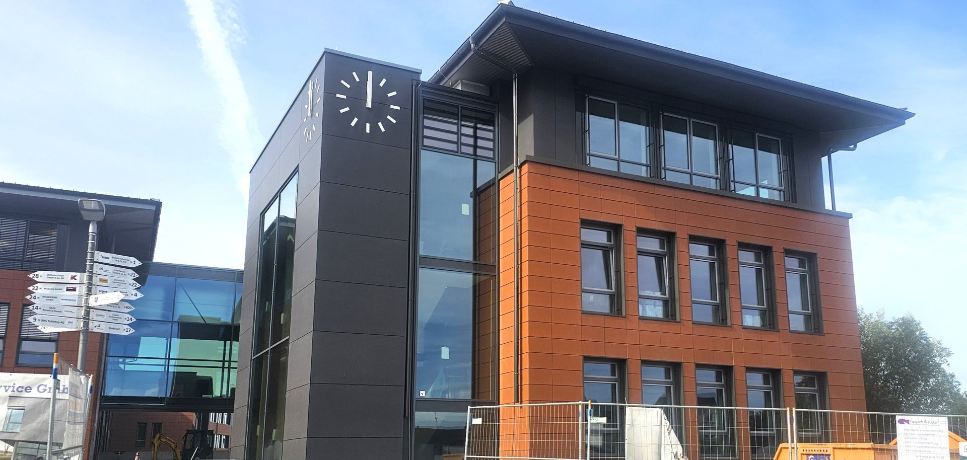 Diese Aufnahme zeigt das Sanierungsobjekt während der Bauarbeiten von außen. Die Fassade scheint bereits fertig zu sein, Innen sind noch Handwerker zugange.