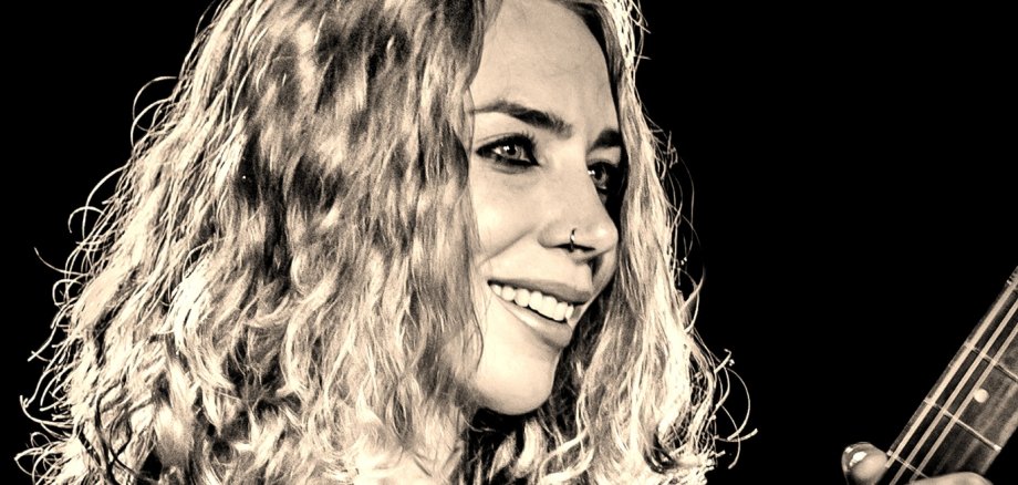 Das Bild zeigt Vanja Sky mit einer Gitarre in der Hand.