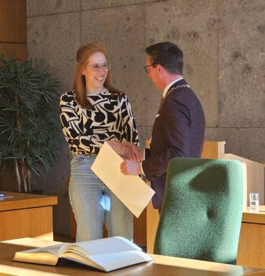 Das Bild zeigt Lisa Hertel-Forster, wie ihr gerade der Dank von Bürgermeister Michael Abraham ausgesprochen wird und ihr eine Urkunde übergeben wird.