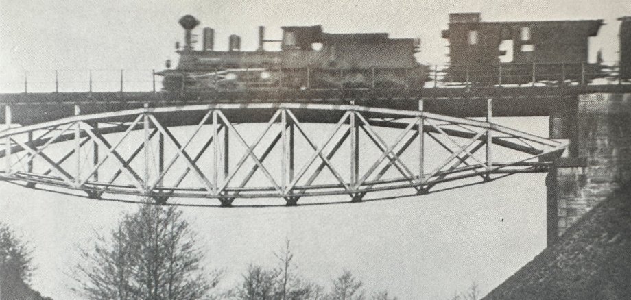 Auf dem schwarz/weiß Bild ist eine Eisenbahn mit Anhänger auf einer Eisenbahnbrücke bei Eulenhammer zu sehen.