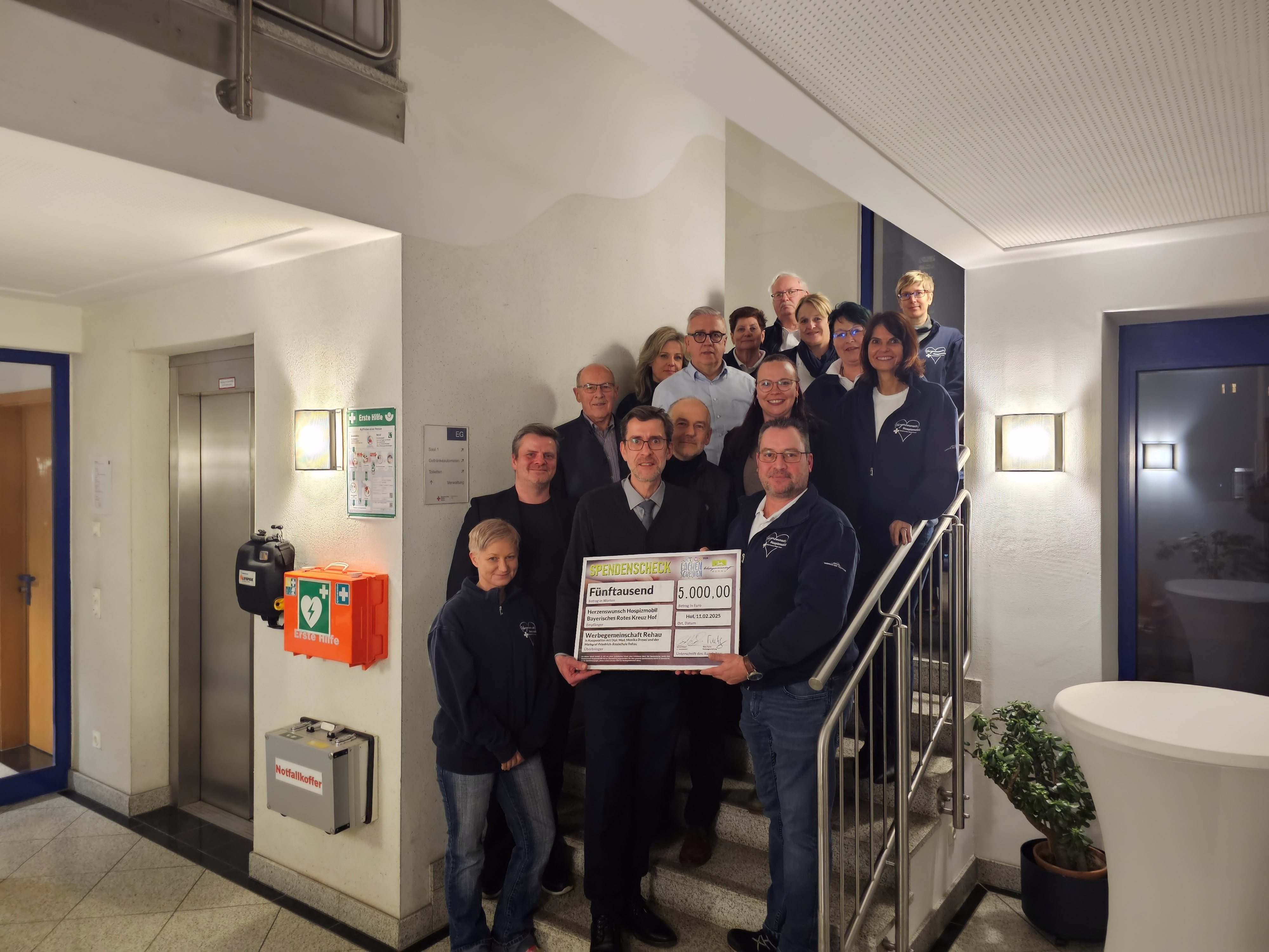 Das Bild zeigt den Vorstand der Werbegemeinschaft, Bernd Köppel, bei der Scheckübergabe an das Team vom Herzenswunschmobil des BRK Kreisverbandes in Hof.