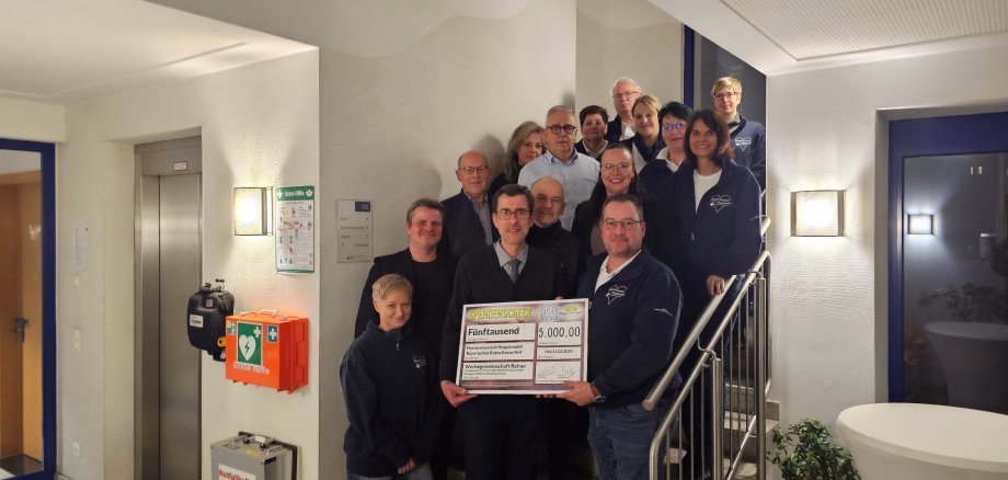 Das Bild zeigt den Vorstand der Werbegemeinschaft, Bernd Köppel, bei der Scheckübergabe an das Team vom Herzenswunschmobil des BRK Kreisverbandes in Hof.