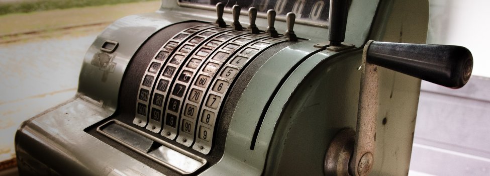 Das Bild zeigt eine sehr alte, grüne Kasse.
