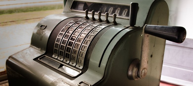 Das Bild zeigt eine sehr alte, grüne Kasse.