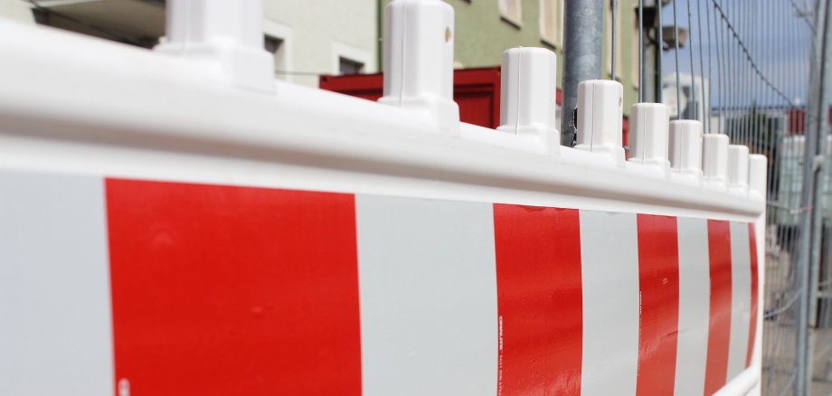 Auf dem Bild ist eine rot-weiße Straßenabsperrung zu sehen. 