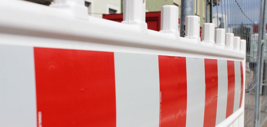 Auf dem Bild ist eine rot-weiße Straßenabsperrung zu sehen. 