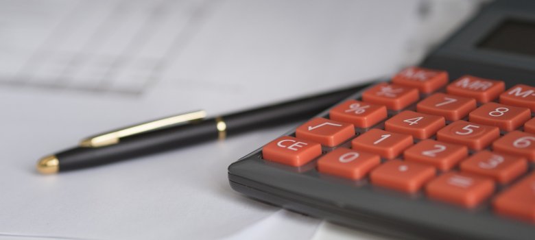 Auf dem Bild ist ein Taschenrechner und ein Stift zu sehen.