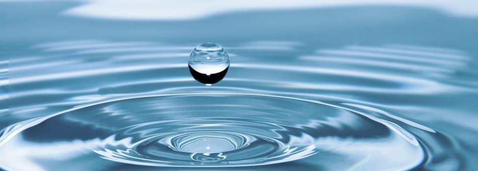 Auf dem Bild ist ein Wassertropfen zu sehen, der kurz vor dem Aufprall auf dem Wasser ist.