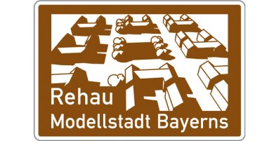 Die Grafik zeigt das braune Autobahnschild "Rehau - Modellstadt Bayerns"