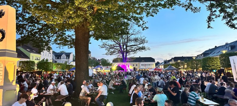 Das Foto zeigt das Bierfestival im Jahr 2026 mit Blick über den Maxplatz und zahlreichen Besuchern im Vordergrund und die Bühne mit musikalischen Darbietungen im Hintergrund.