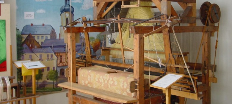 Das Bild zeigt einen Webstuhl, welcher sich in der Roßbacher Weberstube im Rehauer Museum befindet.