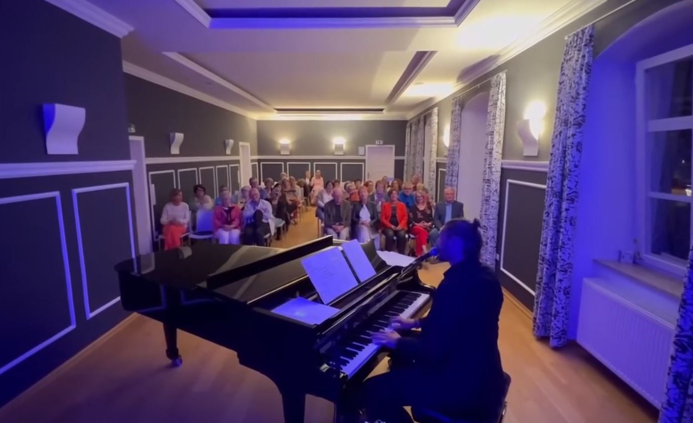 Das Bild zeigt eine Veranstaltung im Festsaal des Alten Rathauses. Im Vordergrund ist ein Musiker am Flügel zu sehen. Dahinter sitzen die Zuhörer.