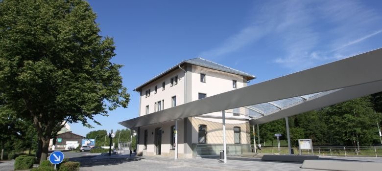 Das Bild zeigt das neue Bahnhofsgebäude von Rehau mit dem neu gestalteten Außenbereich.