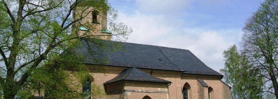 Auf dem Bild ist die Stadtkirche St. Jobst zu sehen. Davor sieht man die grüne Wiese des Friedhofsgartens.