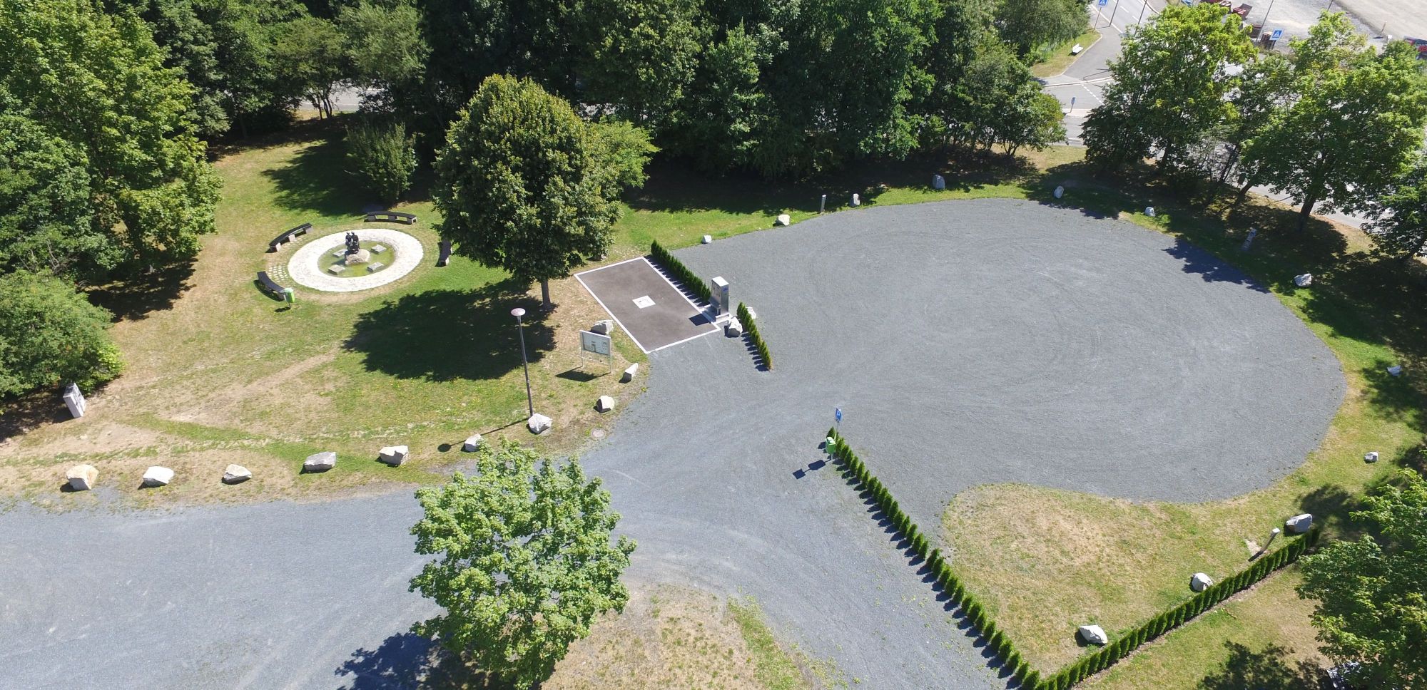 Das Bild zeigt eine Luftaufnahme vom Wohnmobilpark am Siedlerfestplatz. Auch der daneben befindliche Brunnen und Bänke sind zu erkennen.