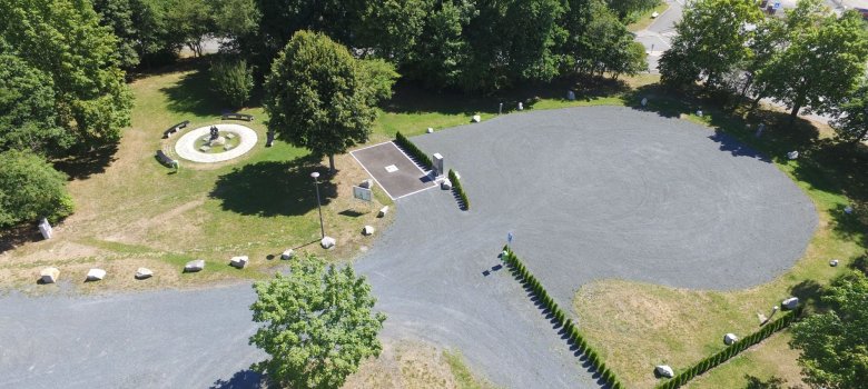 Das Bild zeigt eine Luftaufnahme vom Wohnmobilpark am Siedlerfestplatz. Auch der daneben befindliche Brunnen und Bänke sind zu erkennen.