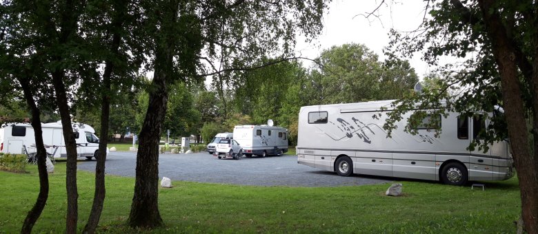 Auf dem Bild ist der Wohnmobilpark auf dem Siedlerfestplatz zu erkennen. Auf dem Bild befinden sich gleichzeitig 4 Wohnmobile auf dem geschotterten Platz.