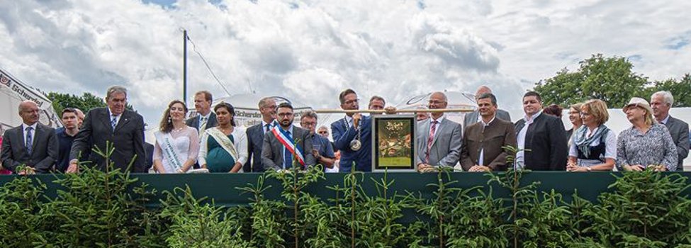 Das Bild zeigt die Ehrengäste des Rehauer Wiesenfests 2019 sowie Bürgermeister Michael Abraham auf der Ehrentribüne mit der Ehrenplakette des Europarates.