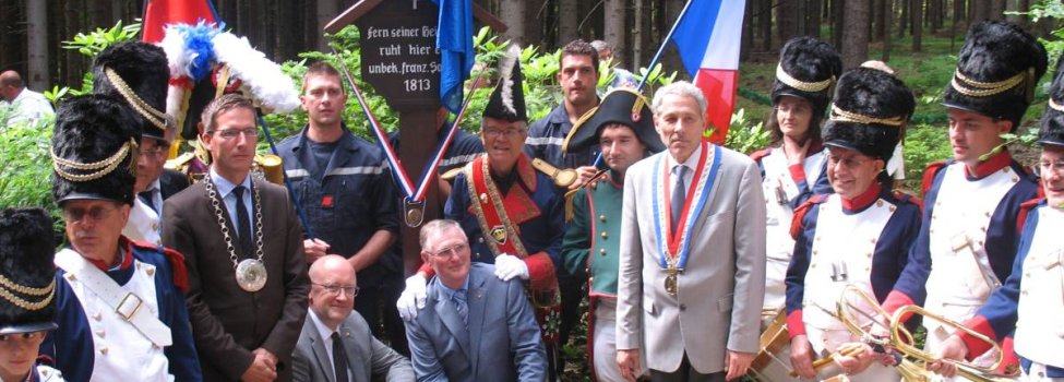 Das Bild zeigt Bürgermeister Abraham und Vertreter der französischen Delegation an einem der beiden Franzosengräber bei Faßmannsreuth.