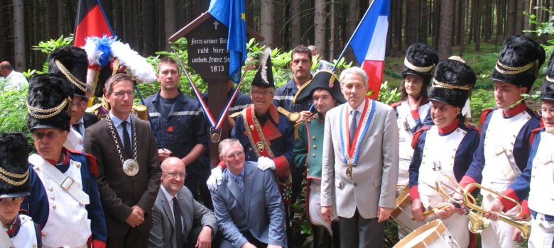 Das Bild zeigt Bürgermeister Abraham und Vertreter der französischen Delegation an einem der beiden Franzosengräber bei Faßmannsreuth.